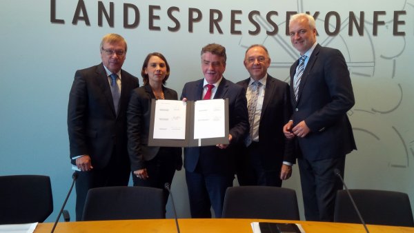 Vertreter des Bündnisses halten das Memorandum in die Kamera. 