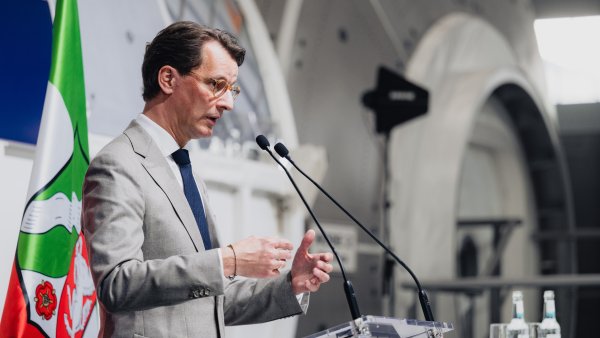 MP Wüst während seiner Rede vor einer Raumfahrtkapsel