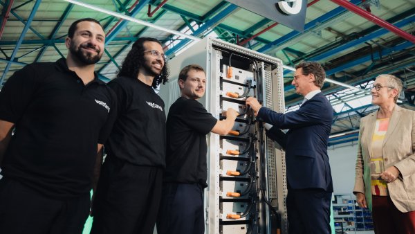 Ministerpräsident Wüst schließt Strom an einem großen Batterieschrank an