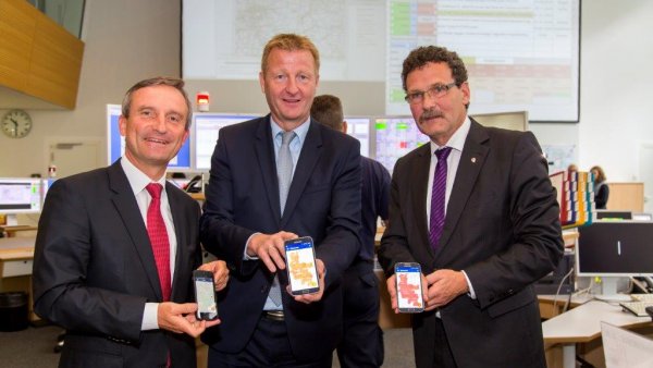 Oberbürgermeister der Stadt Düsseldorf Thomas Geisel, Innenminister Ralf Jäger und Präsidenten des Bundesamtes für Bevölkerungsschutz und Katastrophenhilfe, Christoph Unger stehen nebeneinander und präsentieren die Notfall-, Informations- und Nachrichten-App NINA auf dem Mobiltelefon