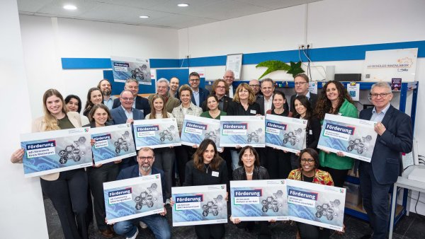 eine Gruppe Menschen hält mehrere Plakate mit den einzelnen Fördernetzwerken hoch 