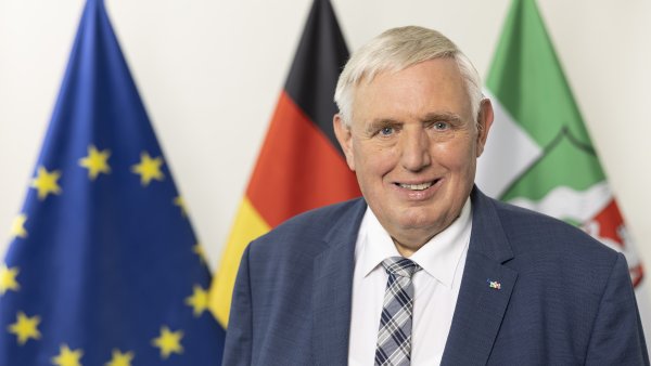 PHB Laumann, Karl-Josef - lächelnd, vor Flaggen (2022)