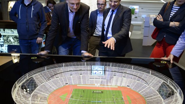 Minister Duin betrachtet eine Stadion-Miniatur