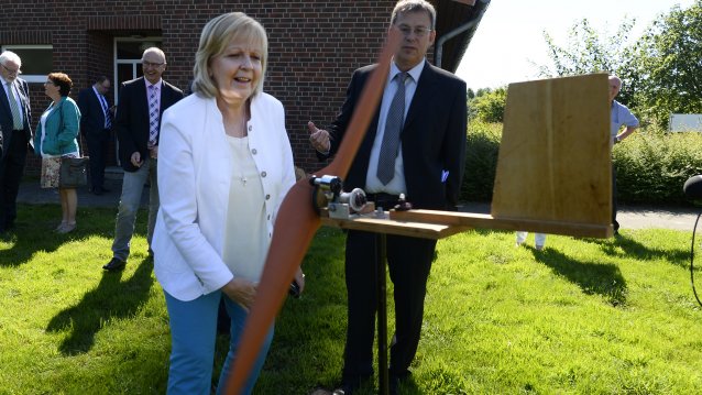 Ministerpräsidentin Hannelore Kraft steht vor einem Holzflugzeug