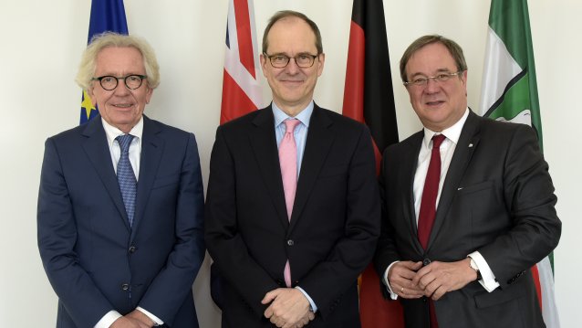 Von links nach rechts: EuropamInister Holthoff-Pförtner, der britische Botschafter Sir Sebastian Wood und Ministerpräsident Armin Laschet. Im Hintergrund die Flaggen von Europa, des Vereinigten Königreiches, Deutschland und Nordrhein-Westfalen. 