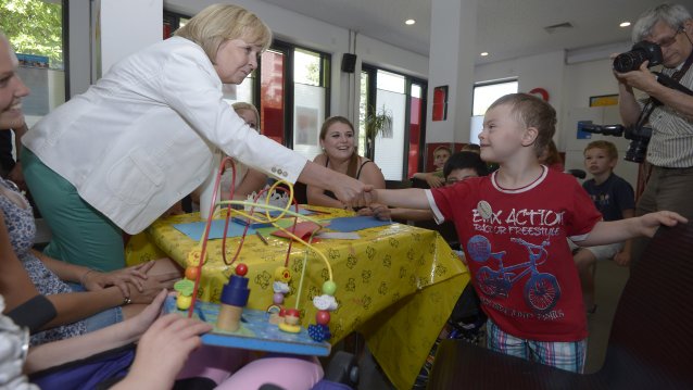 Ministerpräsidentin Hannelore Kraft schüttelt einem behinderten Jungen die Hand