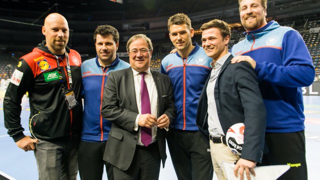 Ministerpräsident Armin Laschet mit der Handball-Mannschaft auf der Spielfläche.