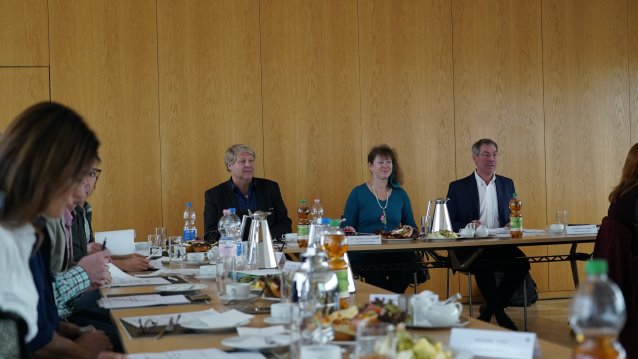 Großaufnahme von Staatssekretärin Andrea Milz mit anderen Teilnehmern in einer Konferenzrunde.
