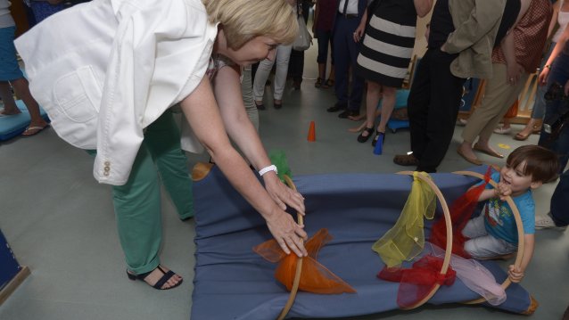 Ministerpräsidentin Hannelore Kraft spielt mit einem Kind auf dem Boden