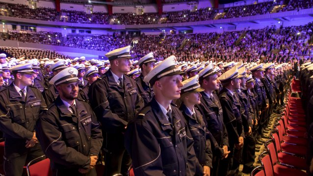 1.920 Polizistinnen und Polizisten des Einstellungsjahrgangs 2016 stehen zur Begrüßung vor ihren Plätzen in der Dortmunder Westfalenhalle.