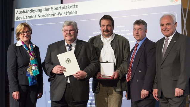 Ministerin Schäfer mit Preisträgern, die ihre Sportplakette in den Händen halten