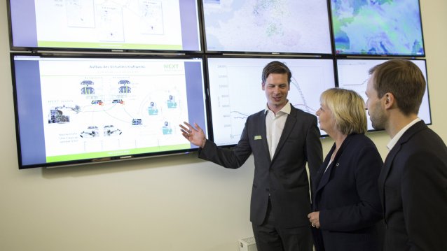 Ein Mitarbeiter erklärt den Aufbau eines virtuellen Netzwerkes an einer Monitor-Wand