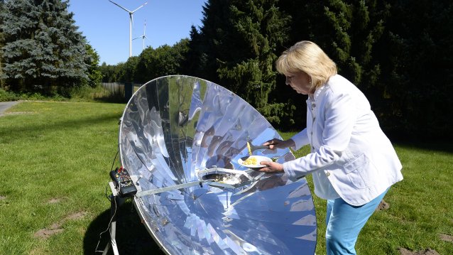 Ministerpräsidentin Hannelore Kraft brät über einem Metallreflektor ein Ei