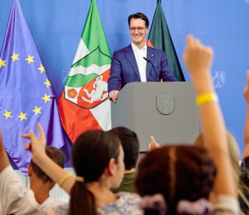 Kinder-Pressekonferenz: Kinder heben den Arm um eine Frage zu stellen