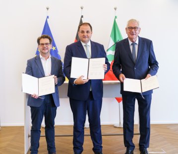 Die 3 Vertreter halten die unterzeichnete Erklärung hoch