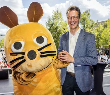 MP Wüst scherzt mit der überlebensgroßen WDR-Maus