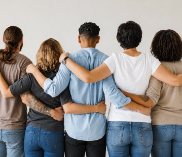 Menschen von hinten, die Arm in Arm stehen