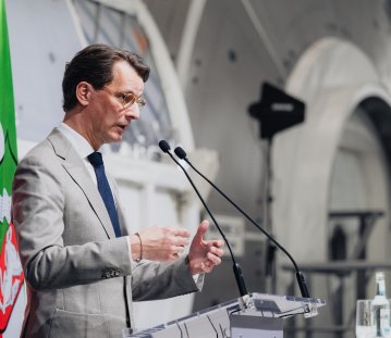 MP Wüst während seiner Rede vor einer Raumfahrtkapsel