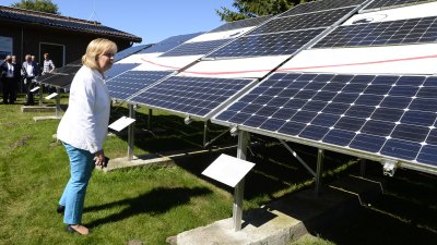 Ministerpräsidentin Hannelore Kraft betrachtet eine Reihe von Solarkollektoren