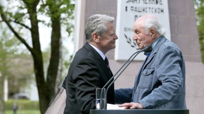 Bundespräsident Joachim Gauck hält die Hände des Überlebenden Lev Frankfurt