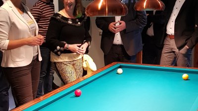 Staatssekretärin Andrea Milz steht mit einer Gruppe um einen Billiardtisch herum.