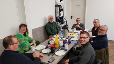 Staatssekretärin Milz sitzt mit Mitgliedern des FC Blau Weiss Friesdorf zusammen an einem gedeckten Tisch.