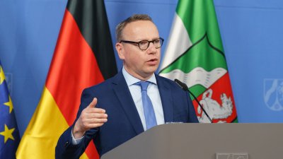 Eine Person spricht am Rednerpult auf einer Pressekonferenz