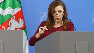 Eine Person spricht am Rednerpult auf einer Pressekonferenz