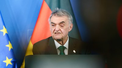 Minister Reul spricht an einem Rednerpult vor Flaggen