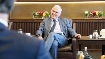 Besprechungssituation in einem festlichen Raum, der Doyen lacht