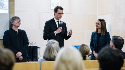 MP Wüst steht in einem Hörsaal und hält eine Ansprache