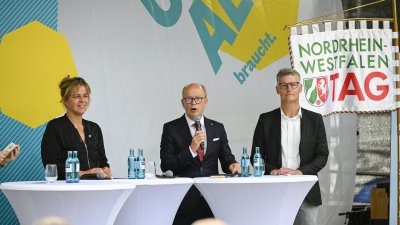 Landtagspräsident Kuper, die stellvertrende Ministerpräsidentin Neubaur und Oberbürgermeister Tilman Fuchs bei der Eröffnung auf einer Bühne