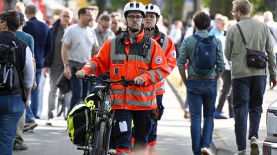 Sanitäter schieben ein Fahrrad auf der Meile
