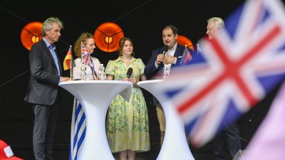 Europaminister Liminski spricht bei einer Podisumsdiskussion - im Vordergrund unscharf die UK-Flagge