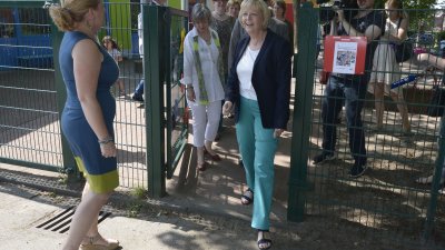 Ministerpräsidentin Hannelore Kraft durschreitet ein Tor zwischen zwei Kindergärten
