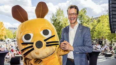 MP Wüst scherzt mit der überlebensgroßen WDR-Maus