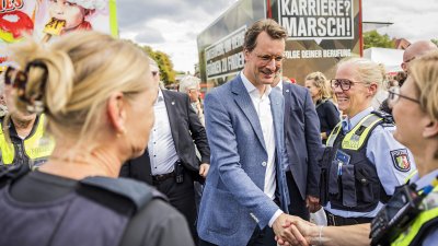 MP Wüst begrüßt auf der Meile eine Polizeibeamtin