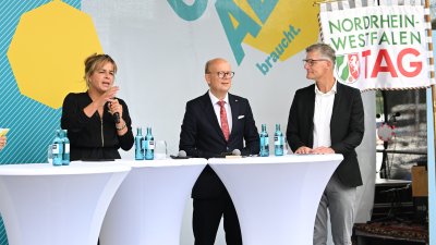 Landtagspräsident Kuper, die stellvertrende Ministerpräsidentin Neubaur und Oberbürgermeister Tilman Fuchs bei der Eröffnung auf einer Bühne