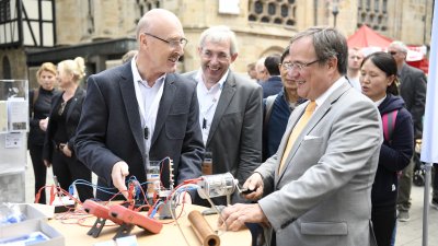 Ministerpräsident Armin Laschet steht an einem Stand mit elektronischen Gerätschaften