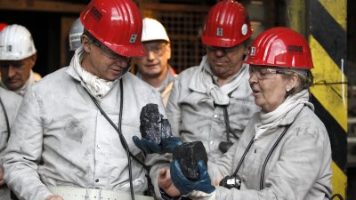 Ministerpräsidentin Kraft überreicht Botschafter Emerson ein Stück Steinkohle während der Grubenfahrt im Bergwerk Auguste Victoria.