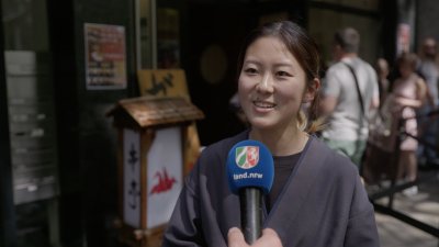 Eine japanische Frau wird auf der Straße befragt