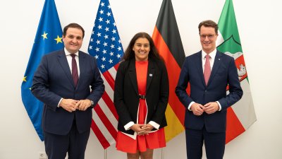 Die Generalkonsulin steht neben dem Ministerpräsidenten und dem Minister Liminski vor den Flaggen der EU, USA, Deutschlands und des Landes Nordrhein-Westfalens.