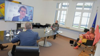 Staatssekretärin Milz nimmt mit 3 Herren in einem Besprechungsraum an einer Videokonferenz teil.