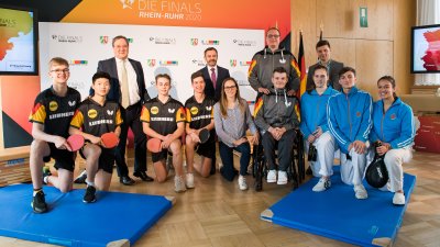 Ministerpräsident Armin Laschet steht mit einem Tischtennisspieler-Team zusammen für ein Portraitbild.