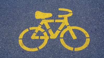 auf Asphalt ist eine gelbe Markierung in Form eines Fahrrades