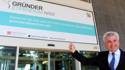  Wirtschaftsminister Pinkwart rechts unten im Bild zeigt lächelnd auf das Gründerstipendium NRW.