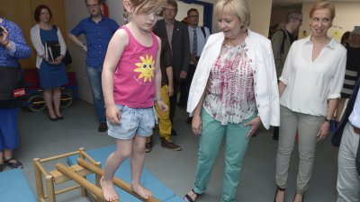 Ministerpräsidentin Hannelore Kraft schaut einem Kind beim Balancieren zu