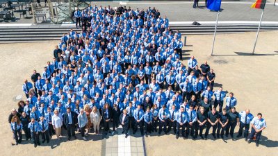 Ein Gruppenfoto aus der Vogelperspektive von den Absolventinnen und Absolventen in blauen Uniformen