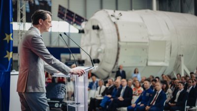 MP Wüst während seiner Rede vor einer Raumfahrtkapsel