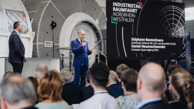Der Moderator steht auf der Bühne